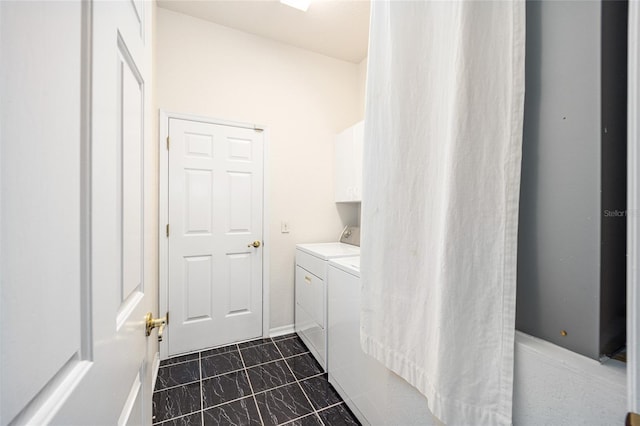 clothes washing area with washer and clothes dryer and cabinets