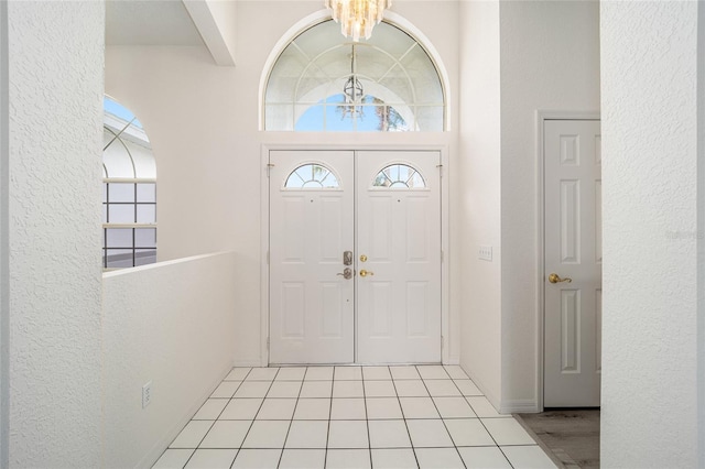 entryway featuring a textured wall, a notable chandelier, and a wealth of natural light