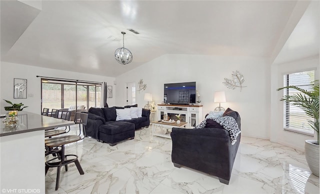 living room featuring a notable chandelier and vaulted ceiling