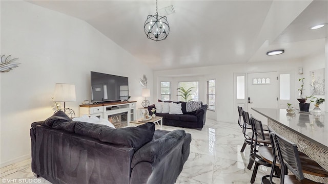 living room featuring an inviting chandelier and vaulted ceiling