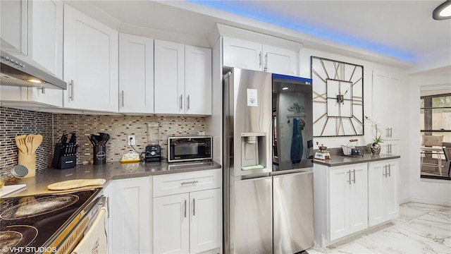 kitchen with backsplash, stainless steel fridge, white cabinets, and wall chimney range hood