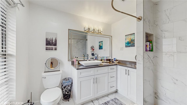 bathroom with a shower, vanity, and toilet