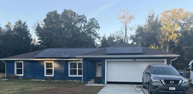 single story home featuring a garage and solar panels