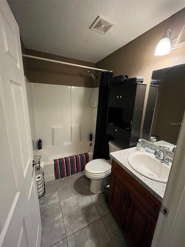 full bathroom featuring toilet, vanity, tile patterned floors, shower / bath combo, and a textured ceiling