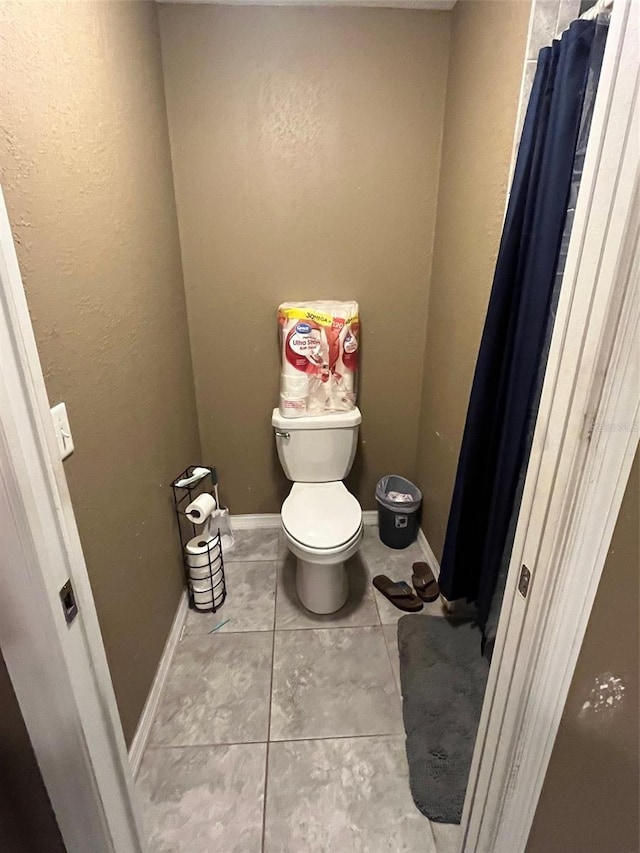 bathroom with toilet and tile patterned flooring