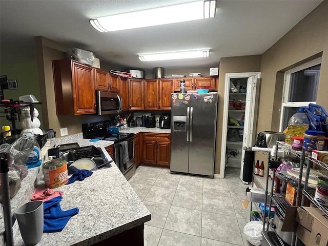 kitchen featuring light tile patterned floors, stainless steel appliances, and sink