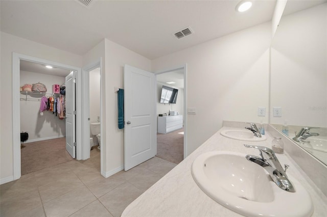 bathroom with tile patterned flooring, vanity, and toilet