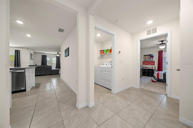 hall featuring light tile patterned flooring and washing machine and clothes dryer