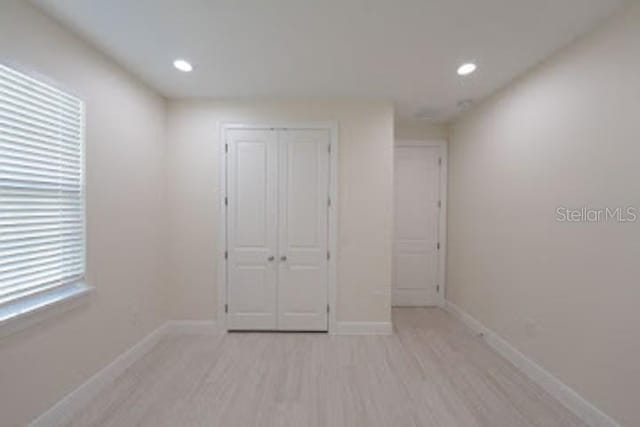 unfurnished bedroom featuring a closet and light hardwood / wood-style flooring