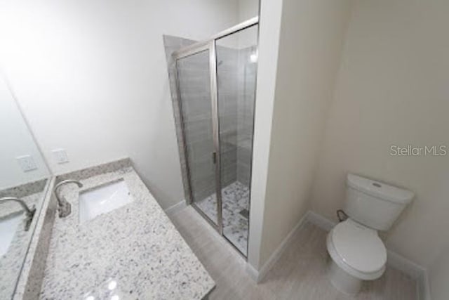 bathroom with vanity, an enclosed shower, and toilet