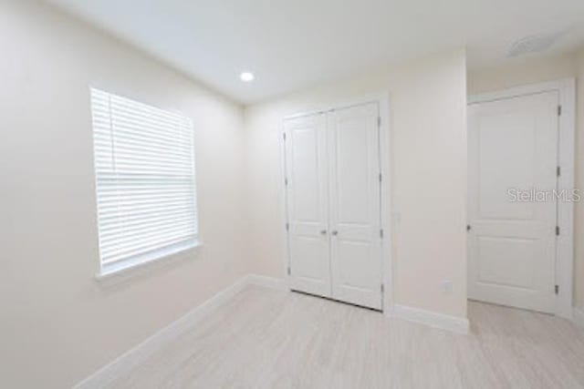 unfurnished bedroom with light wood-type flooring