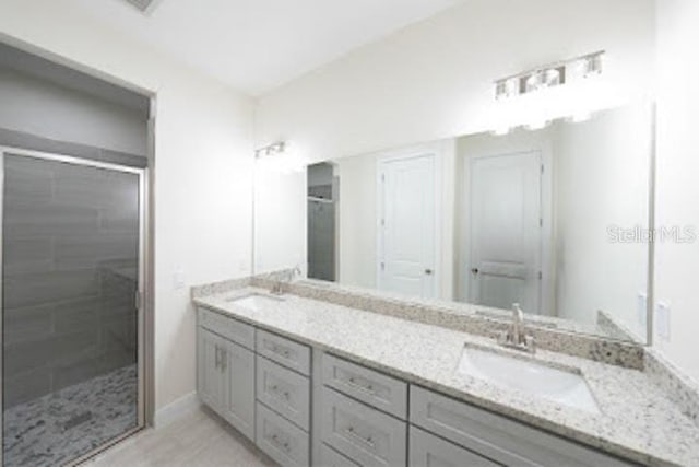 bathroom featuring hardwood / wood-style floors, vanity, and a shower with shower door