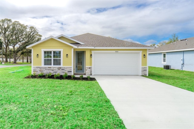 view of front facade featuring a front lawn, central AC unit, driveway, stone siding, and an attached garage