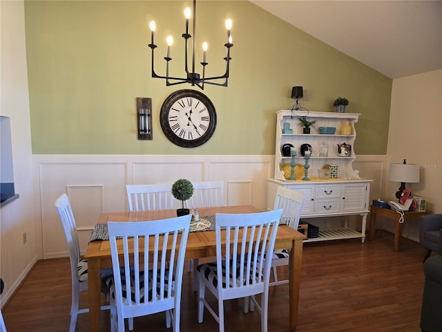 dining space with dark hardwood / wood-style flooring, lofted ceiling, and a notable chandelier