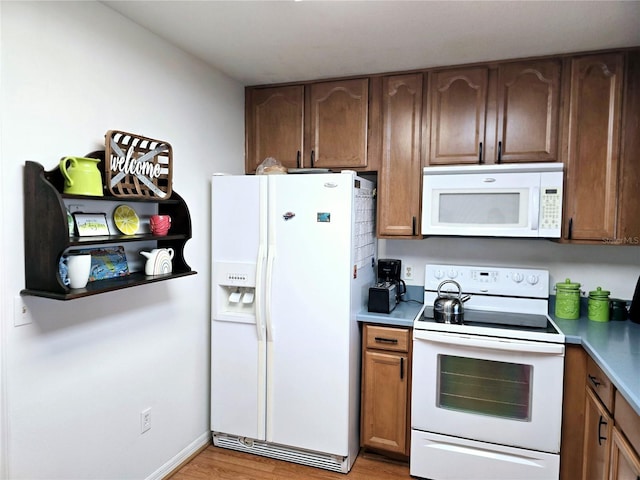 kitchen with light hardwood / wood-style floors and white appliances