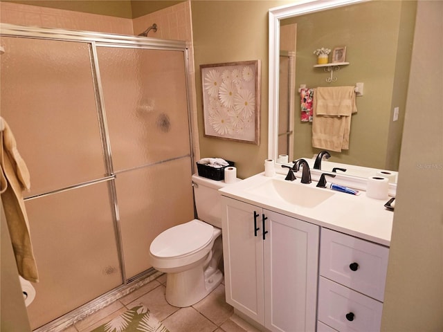 bathroom featuring tile patterned floors, vanity, toilet, and a shower with shower door