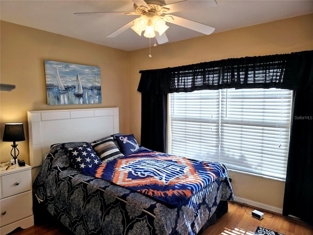 bedroom featuring multiple windows, ceiling fan, and wood-type flooring