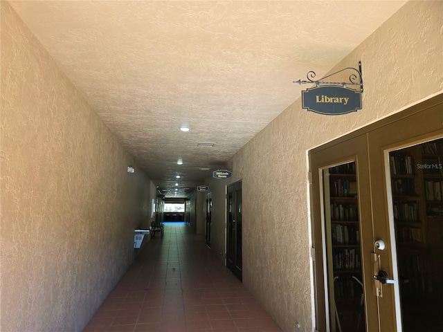 hall featuring dark tile patterned flooring