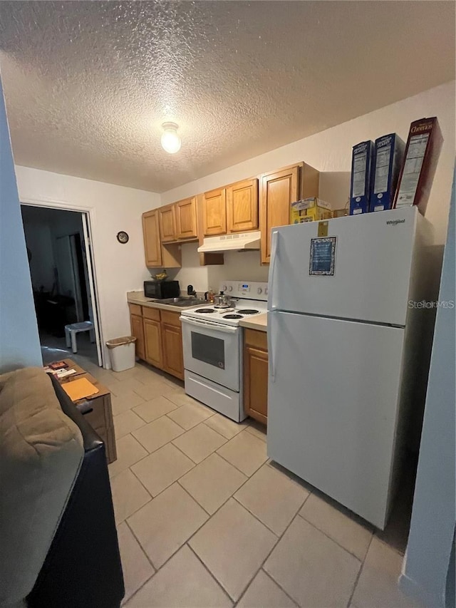 kitchen featuring white appliances, light tile patterned floors, and light brown cabinets