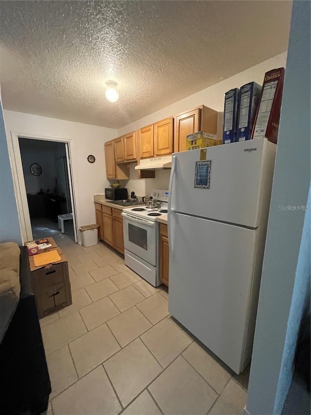 kitchen featuring white appliances, a textured ceiling, and light tile patterned flooring