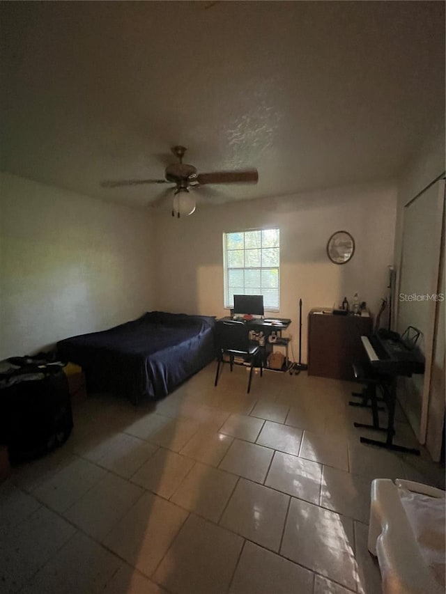 tiled bedroom featuring ceiling fan