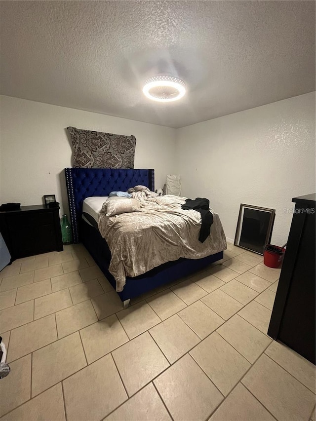 bedroom featuring a textured ceiling and light tile patterned floors