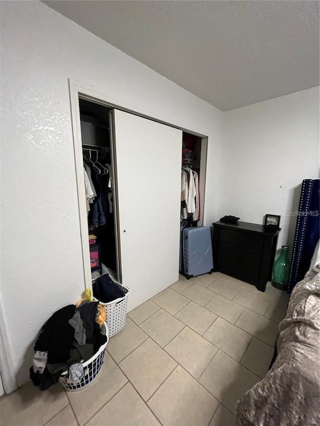 bedroom featuring light tile patterned flooring and a closet