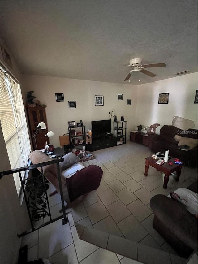 tiled living room featuring a textured ceiling and ceiling fan