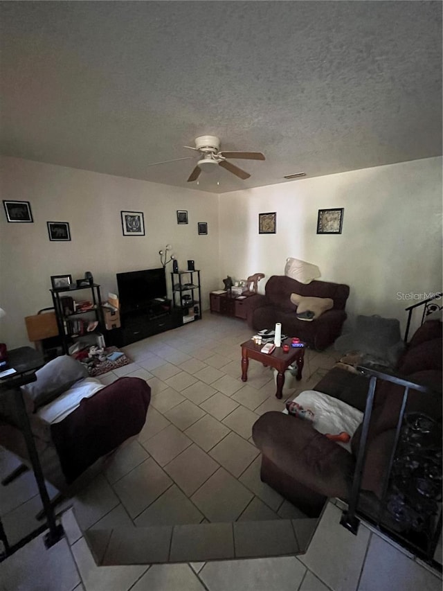 living room featuring a textured ceiling and ceiling fan