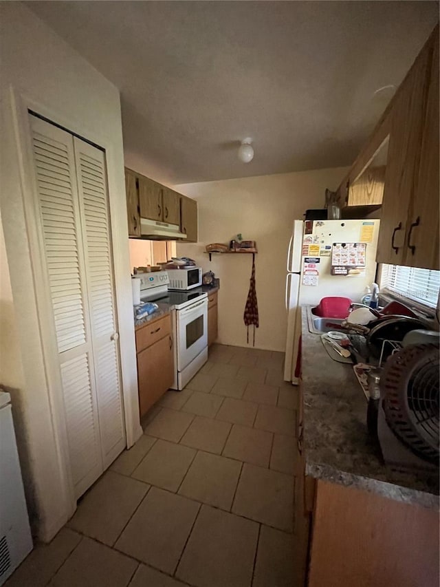 kitchen with white appliances and light tile patterned floors