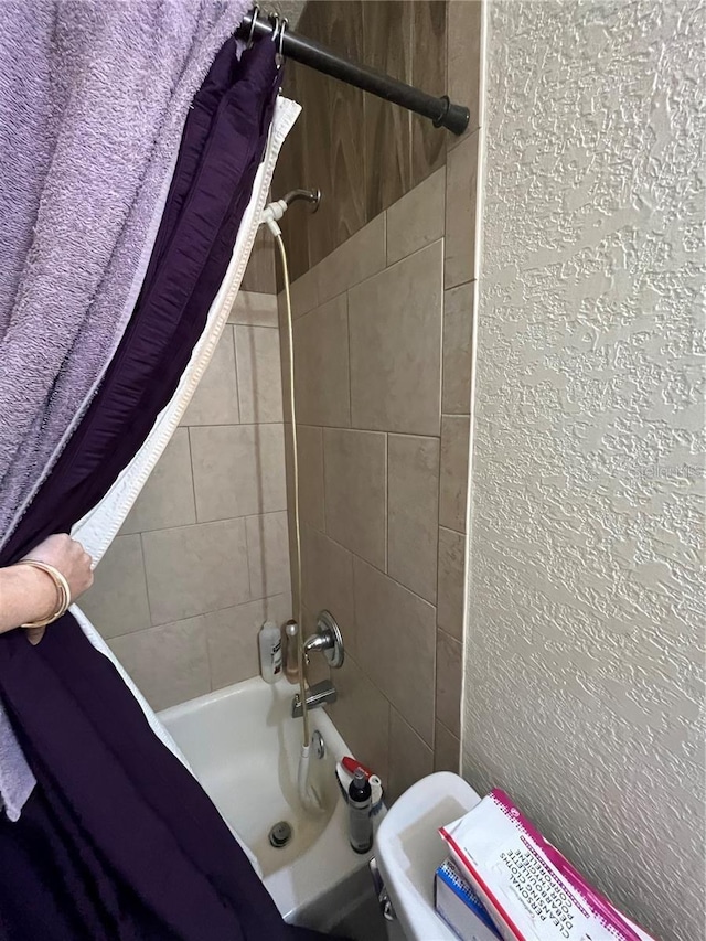 bathroom with shower / bath combo with shower curtain and toilet