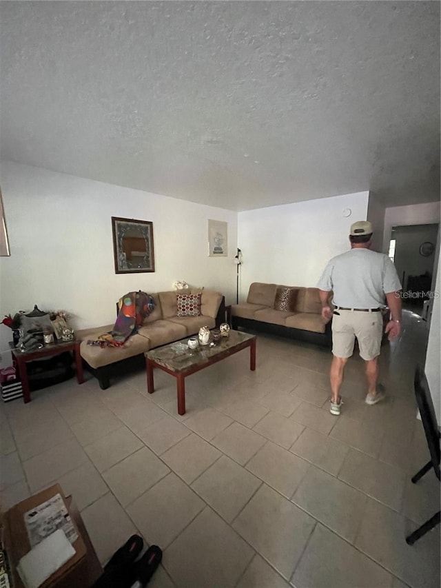 living room featuring a textured ceiling and light tile patterned flooring