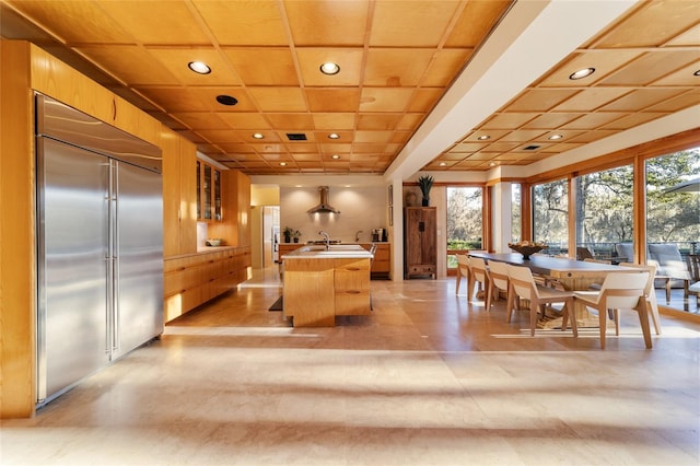 kitchen with a center island, sink, wooden ceiling, island exhaust hood, and stainless steel built in fridge