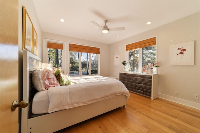 bedroom with multiple windows, ceiling fan, and light hardwood / wood-style floors