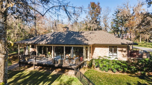 rear view of house featuring a yard and a deck