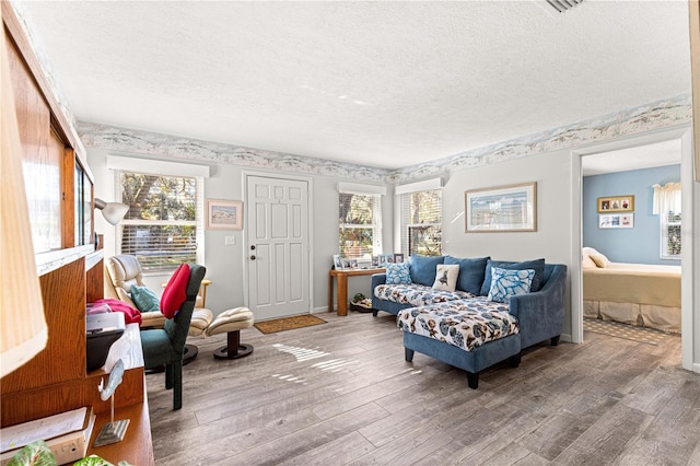 living room with a textured ceiling, hardwood / wood-style flooring, and plenty of natural light