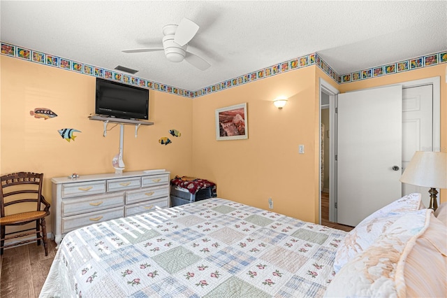 bedroom featuring hardwood / wood-style floors, a textured ceiling, a closet, and ceiling fan