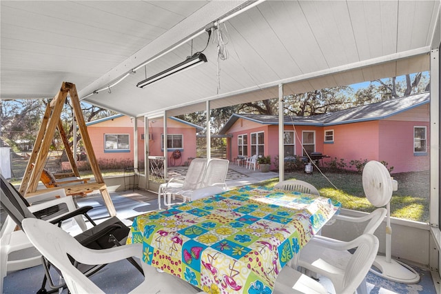 sunroom featuring vaulted ceiling and a healthy amount of sunlight