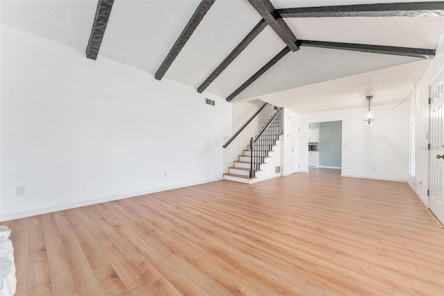 unfurnished living room with beam ceiling, high vaulted ceiling, and light hardwood / wood-style floors