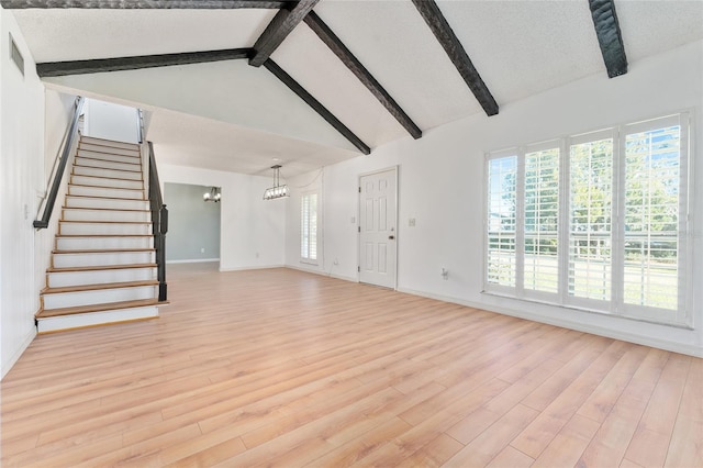 unfurnished living room with light wood-type flooring, a textured ceiling, beam ceiling, high vaulted ceiling, and a notable chandelier