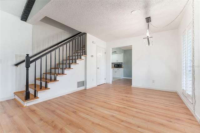 living room featuring light hardwood / wood-style flooring and a textured ceiling