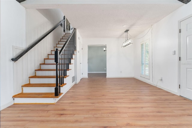 interior space with a chandelier, a textured ceiling, and hardwood / wood-style flooring