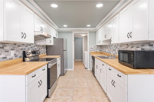 kitchen featuring butcher block counters, sink, decorative backsplash, white cabinets, and black appliances