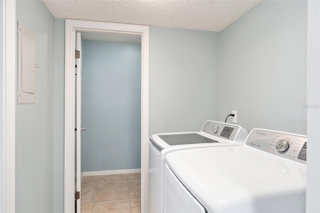 laundry room with washer and dryer, light tile patterned floors, a textured ceiling, and electric panel