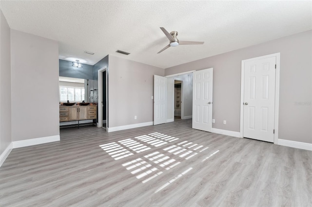 unfurnished bedroom featuring ceiling fan, a textured ceiling, and light hardwood / wood-style flooring