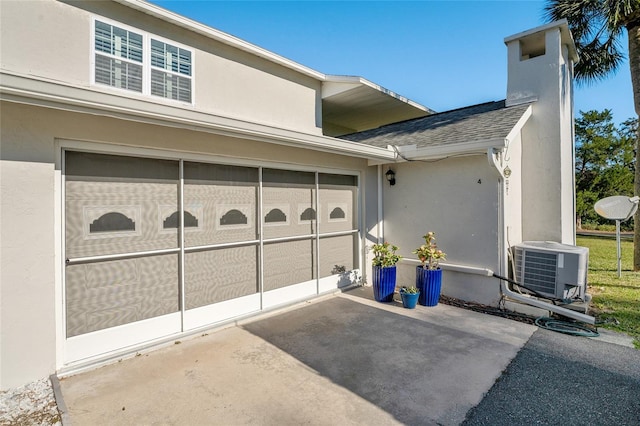 view of side of home with a garage and central air condition unit