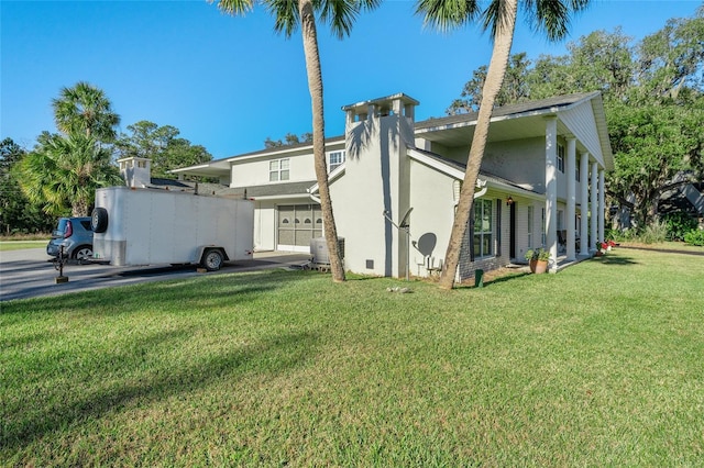 view of side of property featuring a garage and a yard