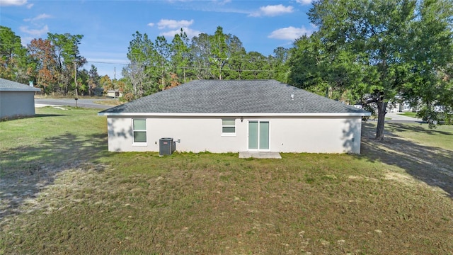 rear view of house featuring a yard and central air condition unit