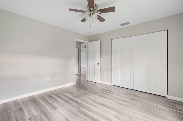 unfurnished bedroom featuring ceiling fan, light hardwood / wood-style floors, and a closet