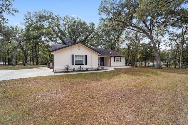 ranch-style house featuring cooling unit and a front lawn